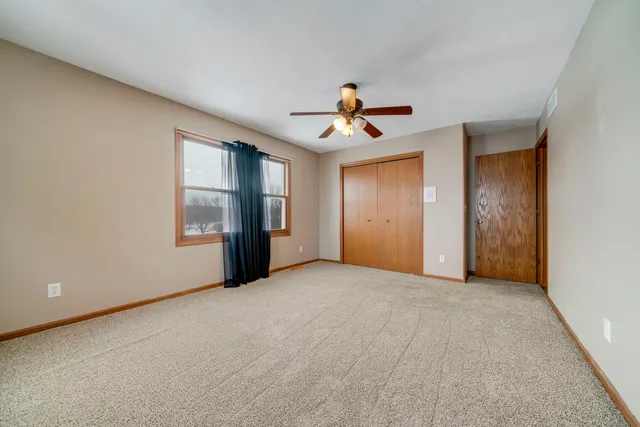 an empty room with chandelier fan