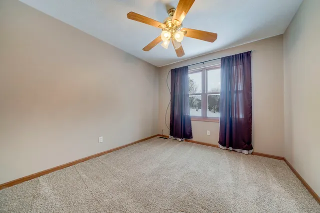 a view of an empty room and chandelier fan