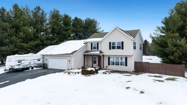 a view of a house with a yard covered in snow