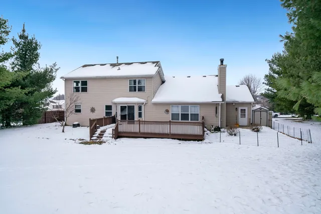 a view of a house with a yard and covered with tall trees