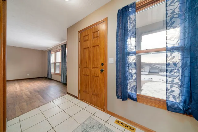 a view of a entrance and room with wooden floor