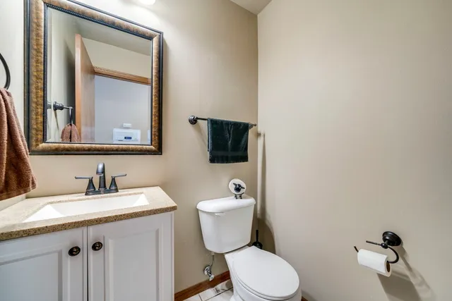 a bathroom with a granite countertop toilet sink and mirror