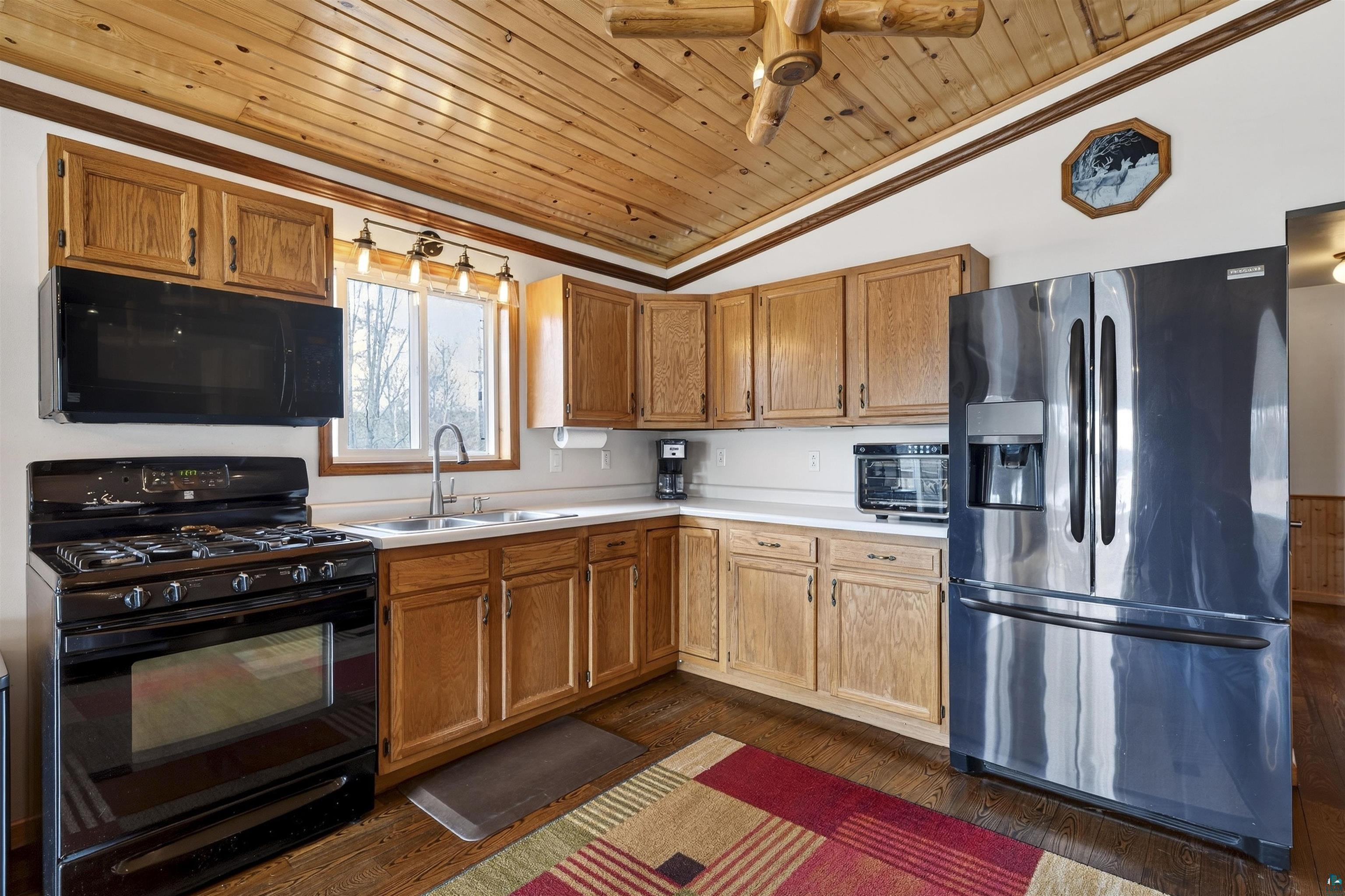 11702 East Mail Road Gordon, WI 54838 - Photo 37 of 49 Kitchen featuring black appliances, light countertops, a vaulted wood ceiling, wood finish cabinetry, and ceiling fan