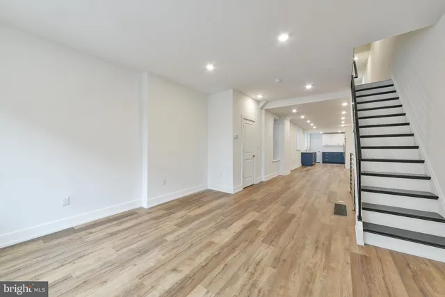 a view of a hallway with stairs and wooden floor