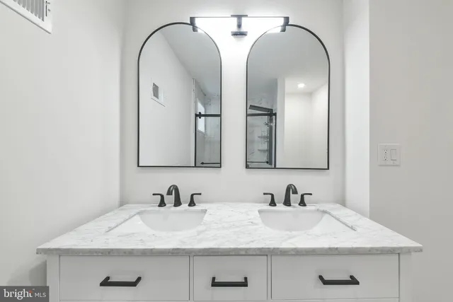 a bathroom with double sink and a mirror
