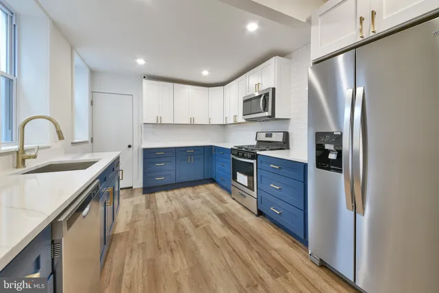 a kitchen with stainless steel appliances granite countertop a refrigerator and a stove top oven