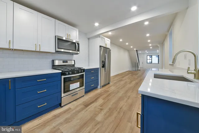 a kitchen with stainless steel appliances kitchen island granite countertop a stove a sink and a microwave