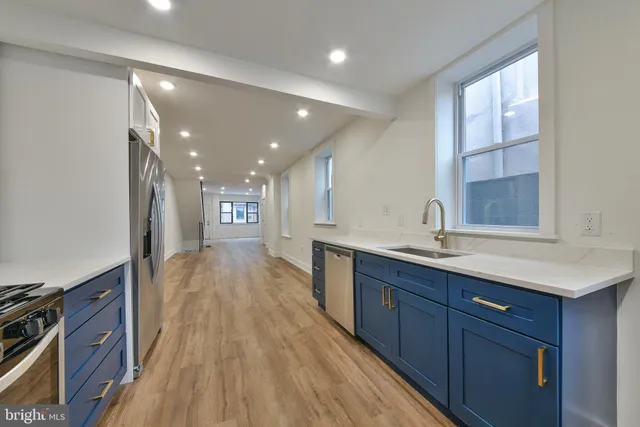 a view of a kitchen island a sink wooden floor and a living room