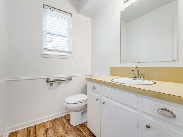 a bathroom with a sink a toilet and a window