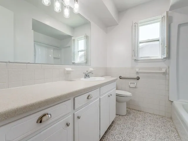 a bathroom with a sink a toilet and a mirror