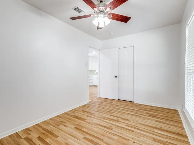 a view of a room with wooden floor and chandelier fan