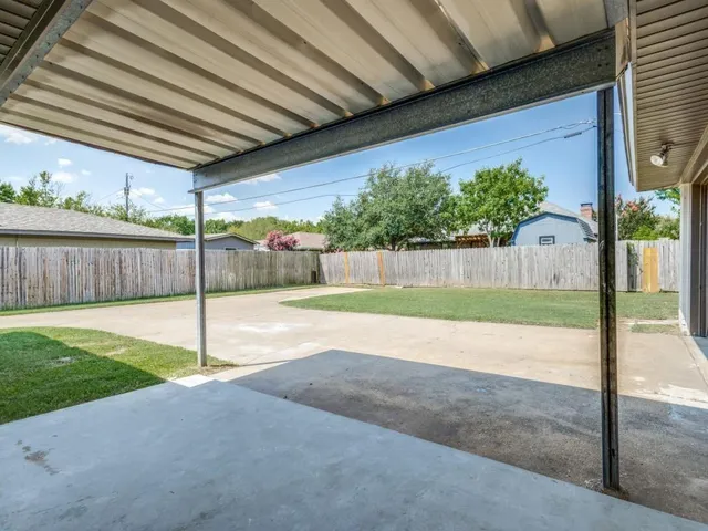 a view of a backyard with wooden fence