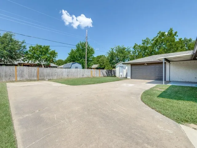 a view of a house with a backyard and a tree