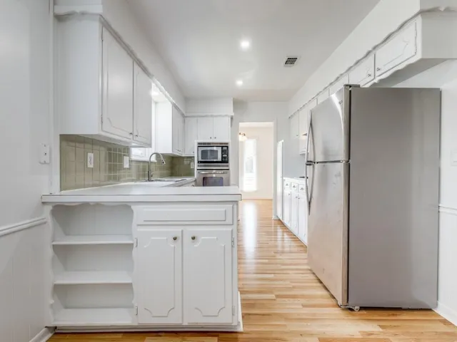 a kitchen with stainless steel appliances a refrigerator and a stove top oven