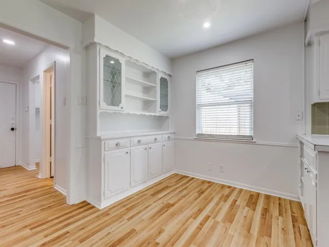 a view of a kitchen with wooden floor and a window