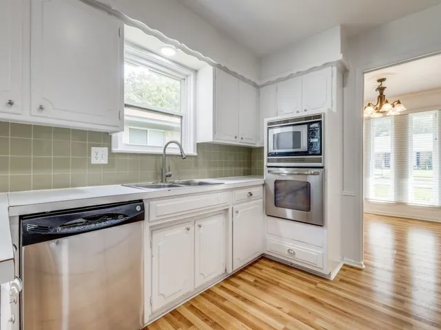 a kitchen with granite countertop a stove a sink and a microwave