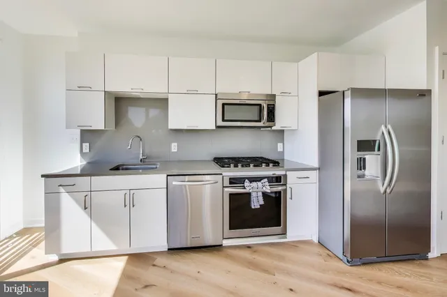a kitchen with stainless steel appliances a stove a sink and a refrigerator