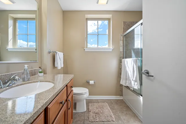 a bathroom with a granite countertop sink toilet and shower