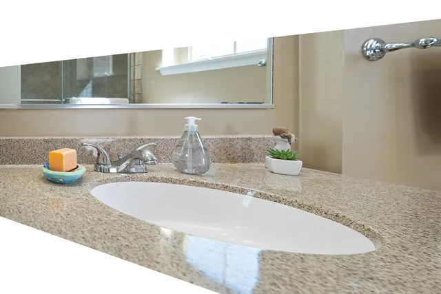 a bathroom with a granite countertop sink and a mirror