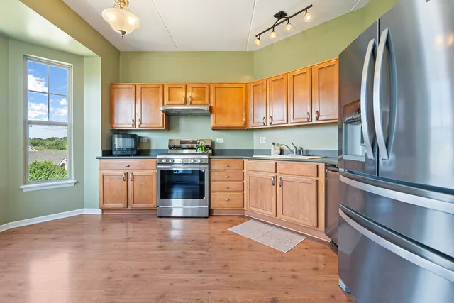 a kitchen with stainless steel appliances granite countertop a stove a sink and a microwave