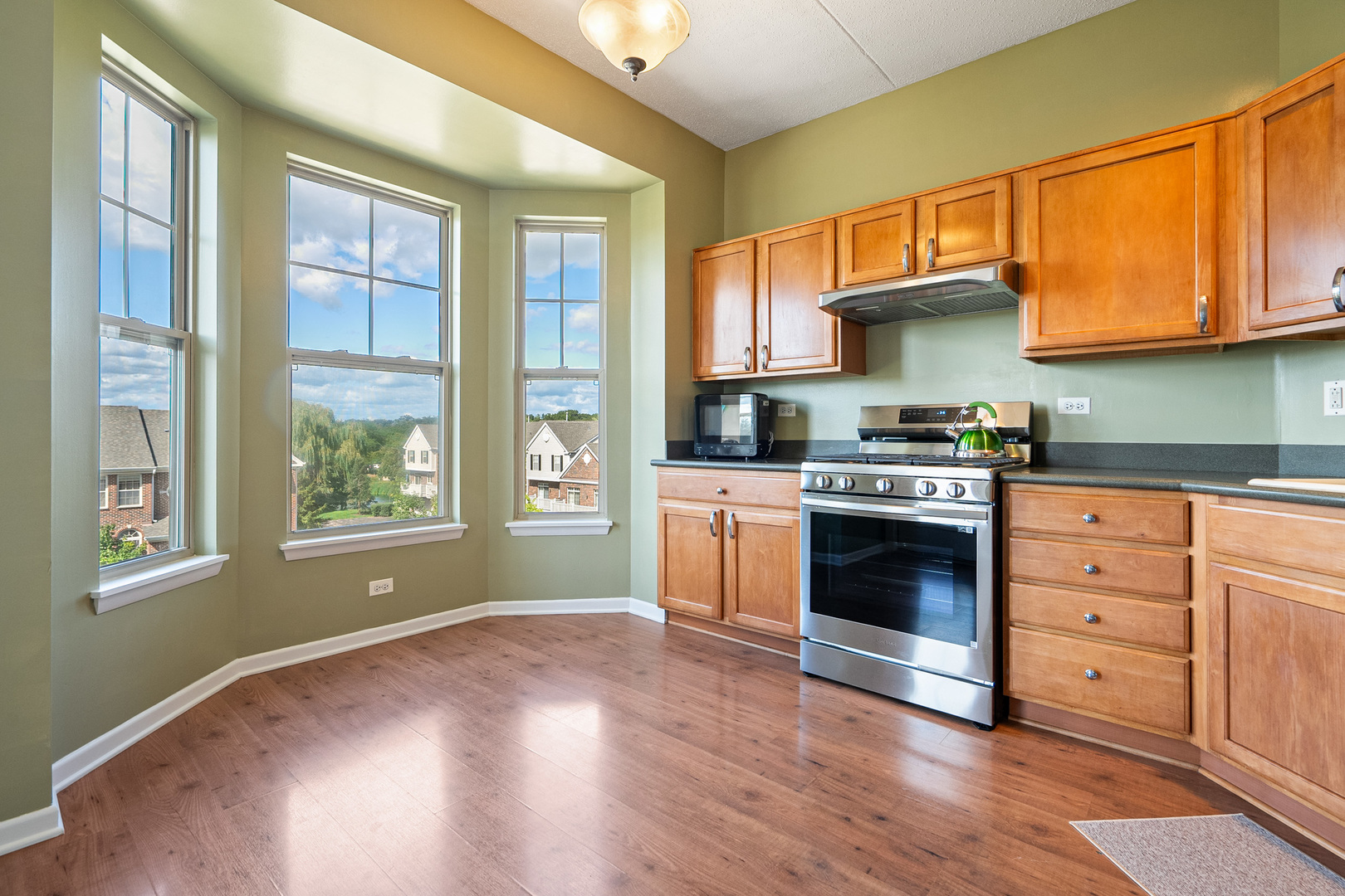 511 Prestwick Lane, Unit 402 Wheeling, IL 60090 - Photo 21 of 27 a kitchen with stainless steel appliances granite countertop a stove a sink and a microwave