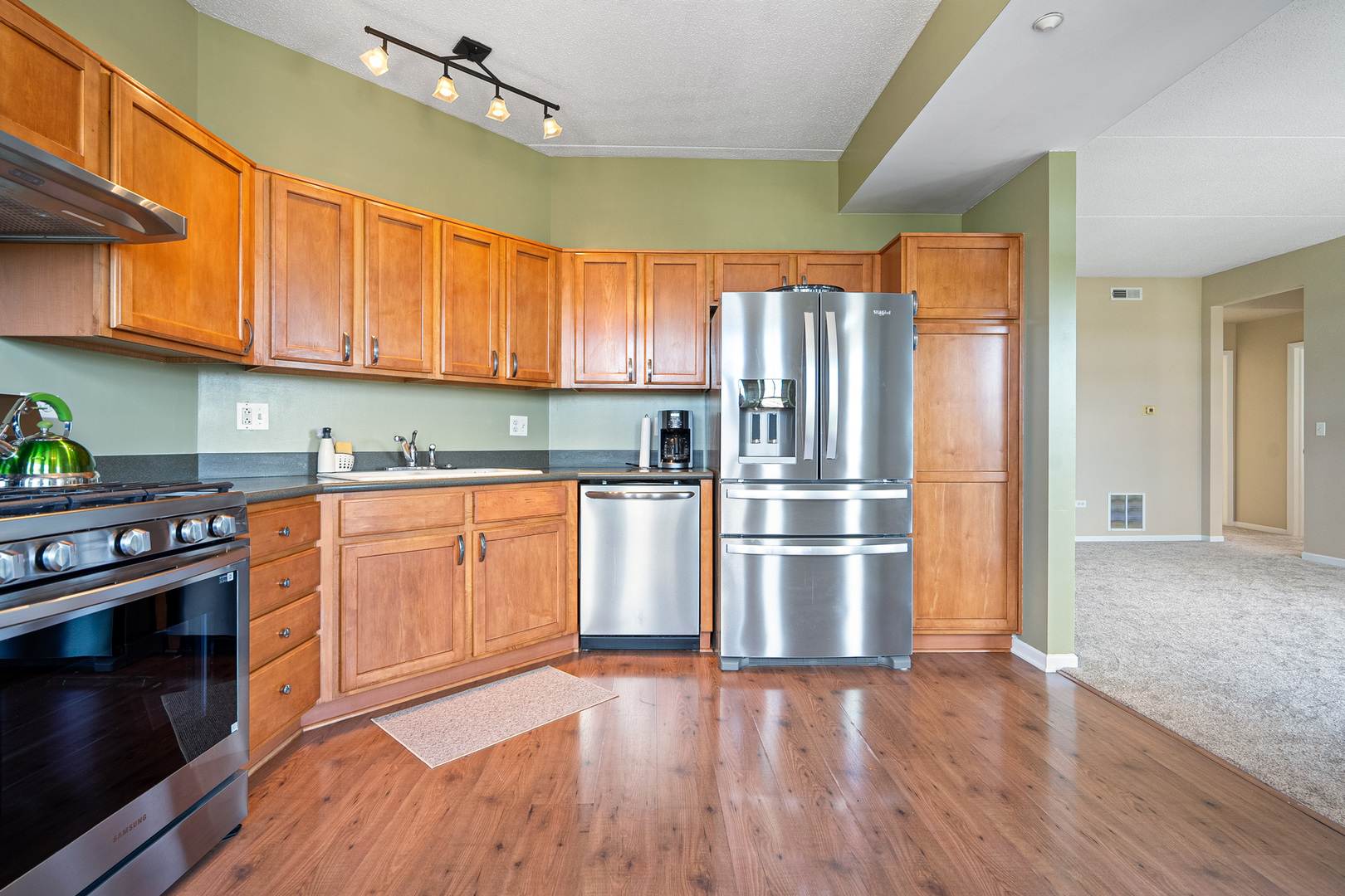 511 Prestwick Lane, Unit 402 Wheeling, IL 60090 - Photo 22 of 27 a kitchen with a refrigerator stainless steel appliances wooden floor and cabinets