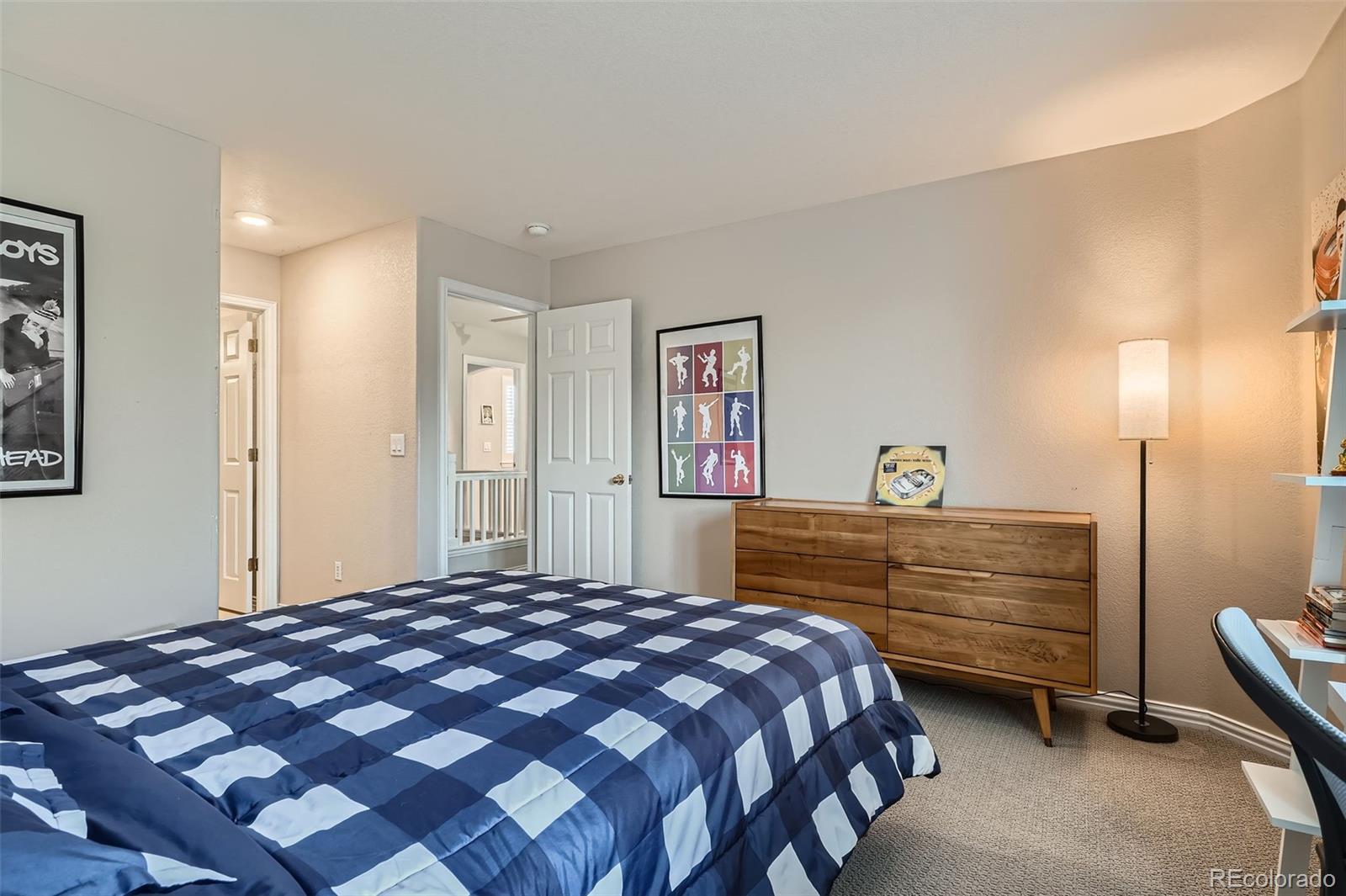 8300 Fairmount Drive, Unit AA102 Denver, CO 80247 - Photo 18 of 27 a bedroom with a bed and a dresser