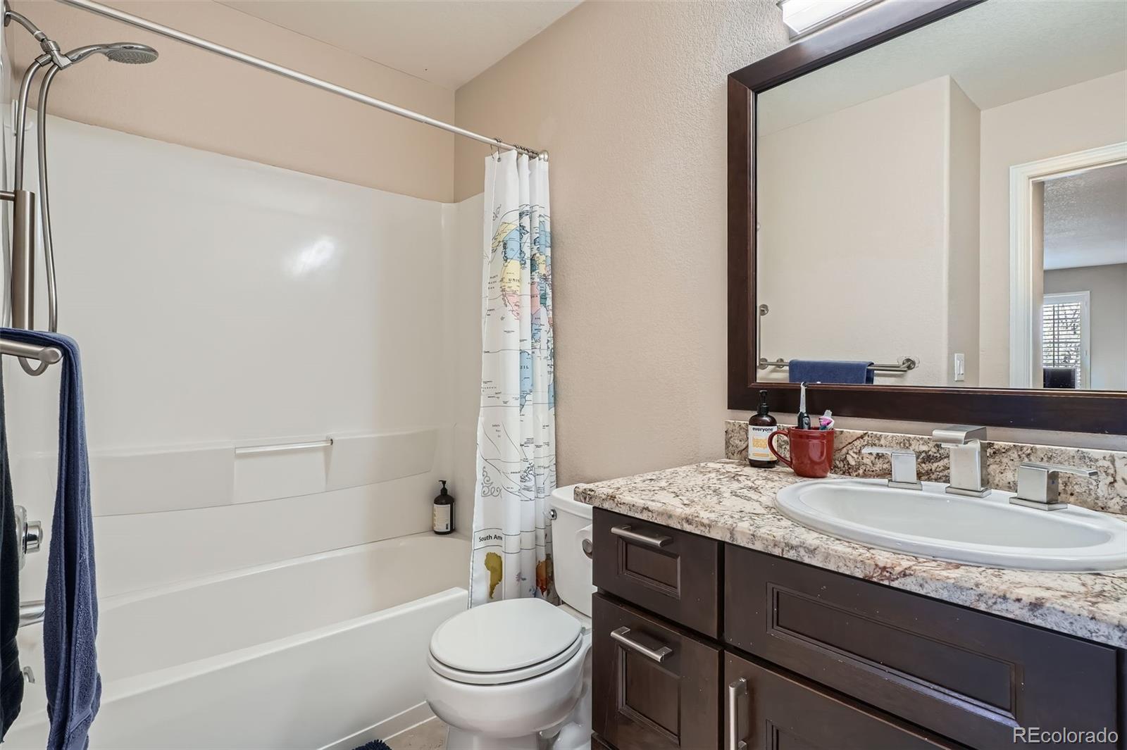 8300 Fairmount Drive, Unit AA102 Denver, CO 80247 - Photo 19 of 27 a bathroom with a granite countertop sink toilet mirror and shower