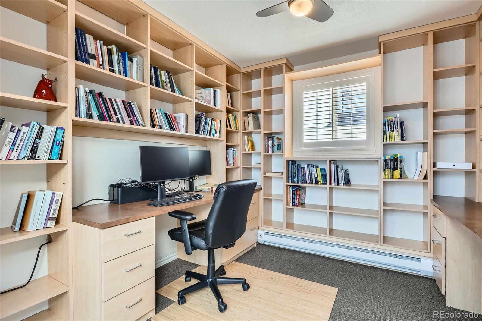 8300 Fairmount Drive, Unit AA102 Denver, CO 80247 - Photo 22 of 27 a view of a workspace with bookshelf and a window