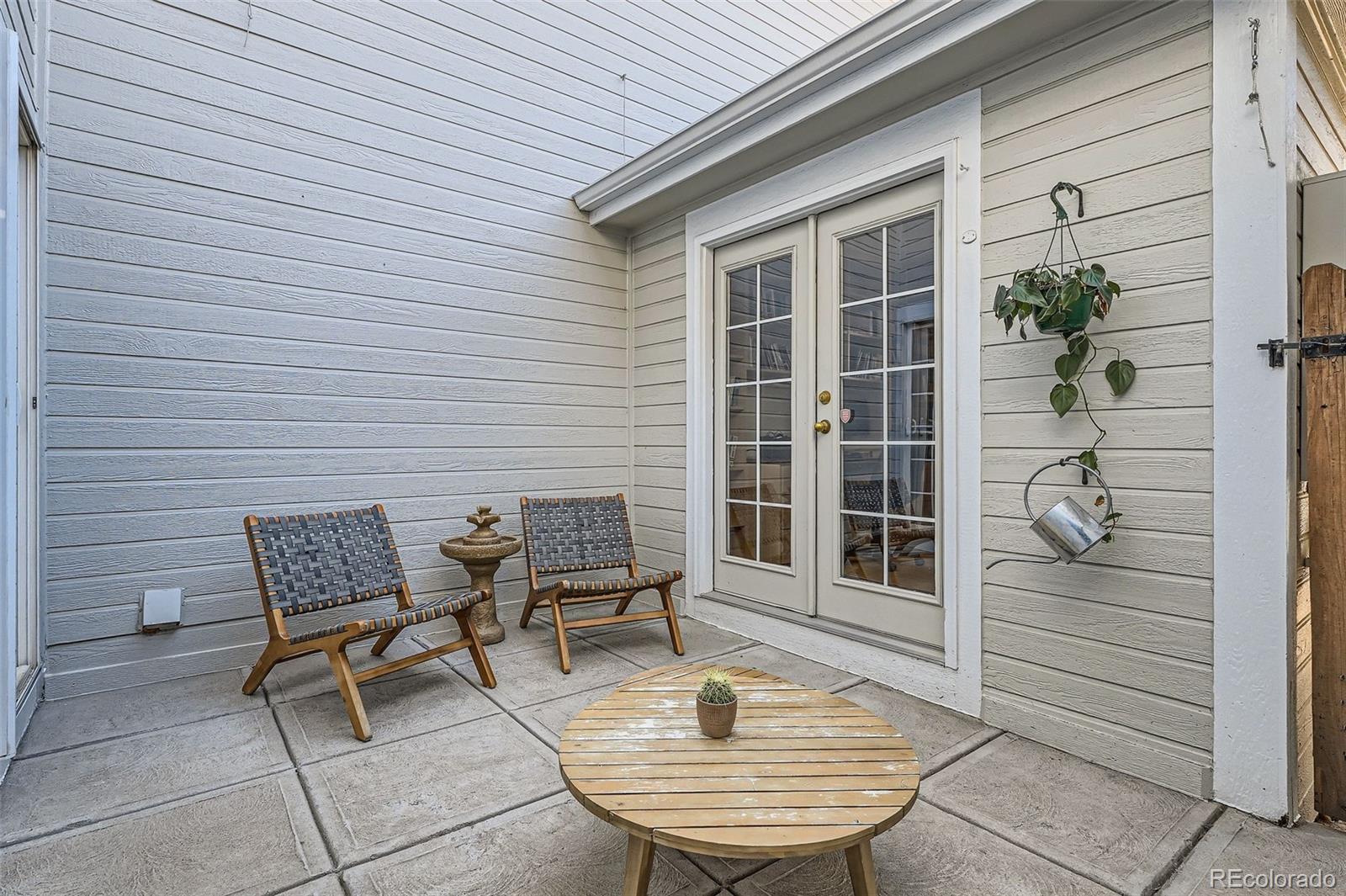 8300 Fairmount Drive, Unit AA102 Denver, CO 80247 - Photo 26 of 27 a patio with table and chairs and potted plants