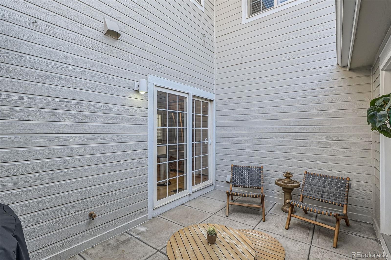 8300 Fairmount Drive, Unit AA102 Denver, CO 80247 - Photo 27 of 27 a view of a patio with a table and chair and wooden floor