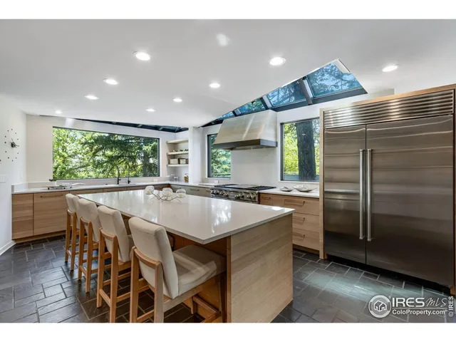 a kitchen with stainless steel appliances granite countertop a sink a stove a refrigerator and island