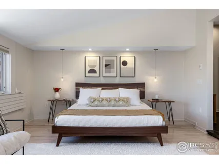 a bedroom with a bed wooden floor and window