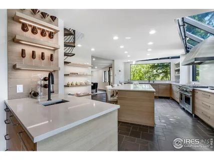 a kitchen with stainless steel appliances kitchen island granite countertop a sink and white cabinets with wooden floor