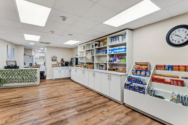 a room with lots of tables a large window and chairs
