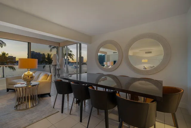 a living room with furniture a rug potted plant and a large window