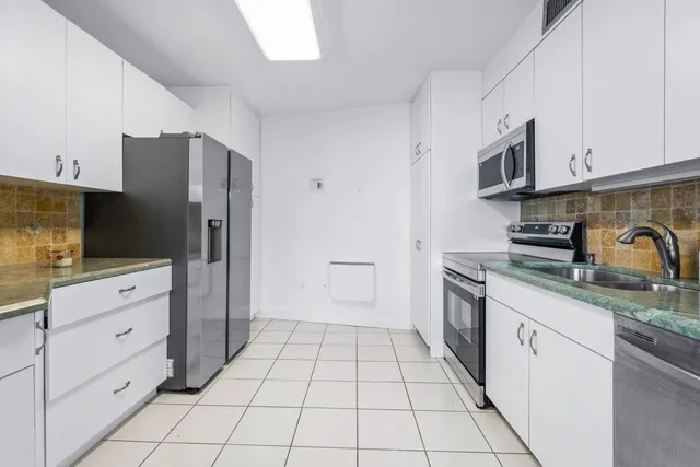 a kitchen with stainless steel appliances a refrigerator sink and cabinets