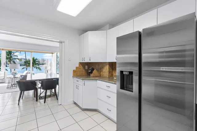 a kitchen with stainless steel appliances kitchen island granite countertop a refrigerator and a sink