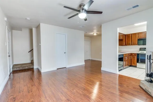 a view of a livingroom with wooden floor and a ceiling fan