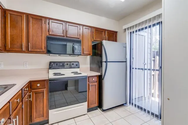 a kitchen with stainless steel appliances granite countertop a refrigerator and a stove top oven