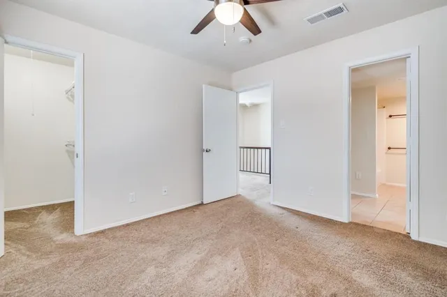 an empty room with fan and entrance