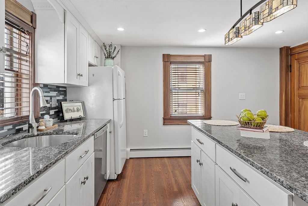 42 Stevens Street, Unit 42 Andover, MA 01810 - Photo 9 of 19 a kitchen with granite countertop kitchen island wooden floor cabinets and a sink