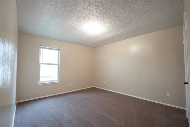 an empty room with a window and a fireplace
