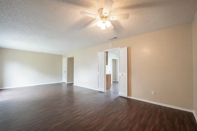 a view of an empty room with wooden floor