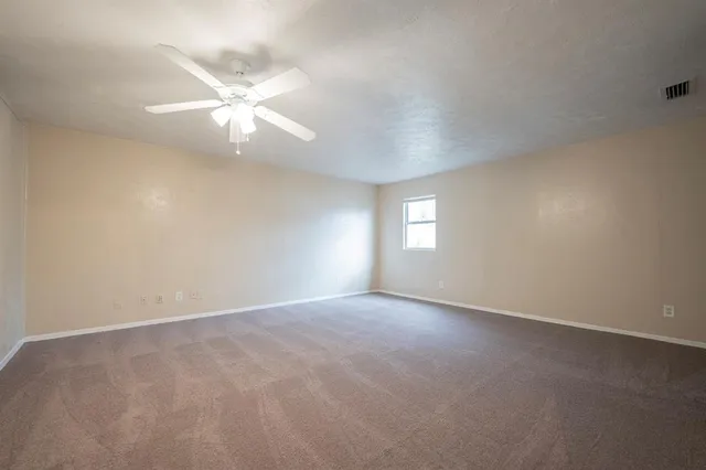 an empty room with windows and fan window