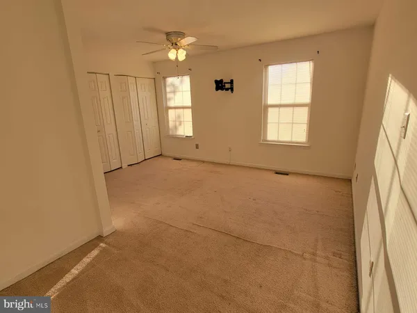 an empty room with windows and closet