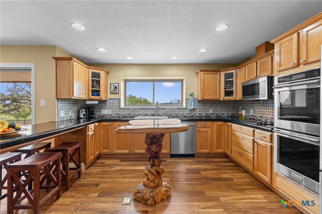 404 Skyline Road Georgetown, TX 78628 - Photo 14 of 40 a kitchen with stainless steel appliances granite countertop a stove a sink and a microwave