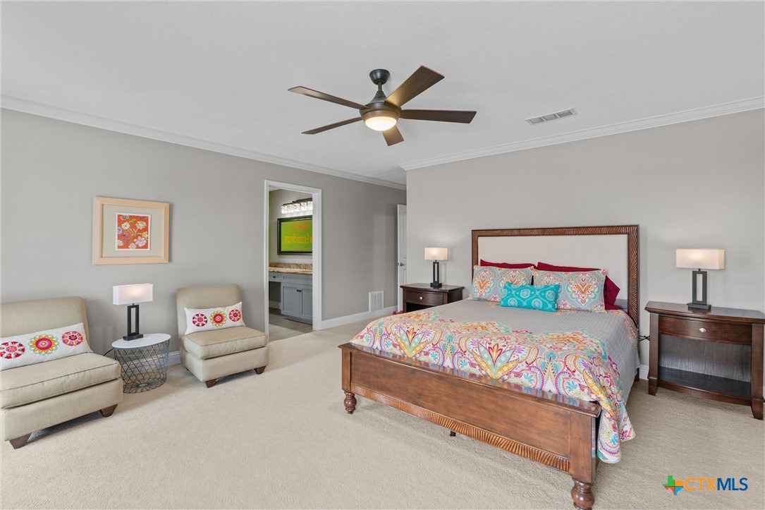 404 Skyline Road Georgetown, TX 78628 - Photo 18 of 40 a bedroom with a bed and a chandelier