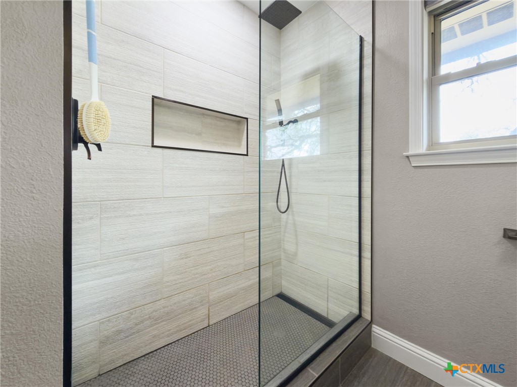 404 Skyline Road Georgetown, TX 78628 - Photo 21 of 40 a bathroom with a glass shower door