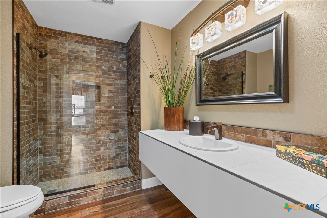 404 Skyline Road Georgetown, TX 78628 - Photo 24 of 40 a bathroom with a sink a toilet and shower